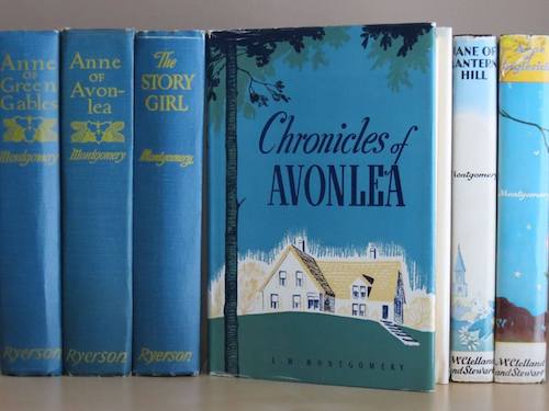Photo of six antiquarian hardcover books on a shelf: Anne of Green Gables, Anne of Avonlea, The Story Girl, Chronicles of Avonlea, Jane of Lantern Hill, and Anne of Ingleside, all by L.M. Montgomery.